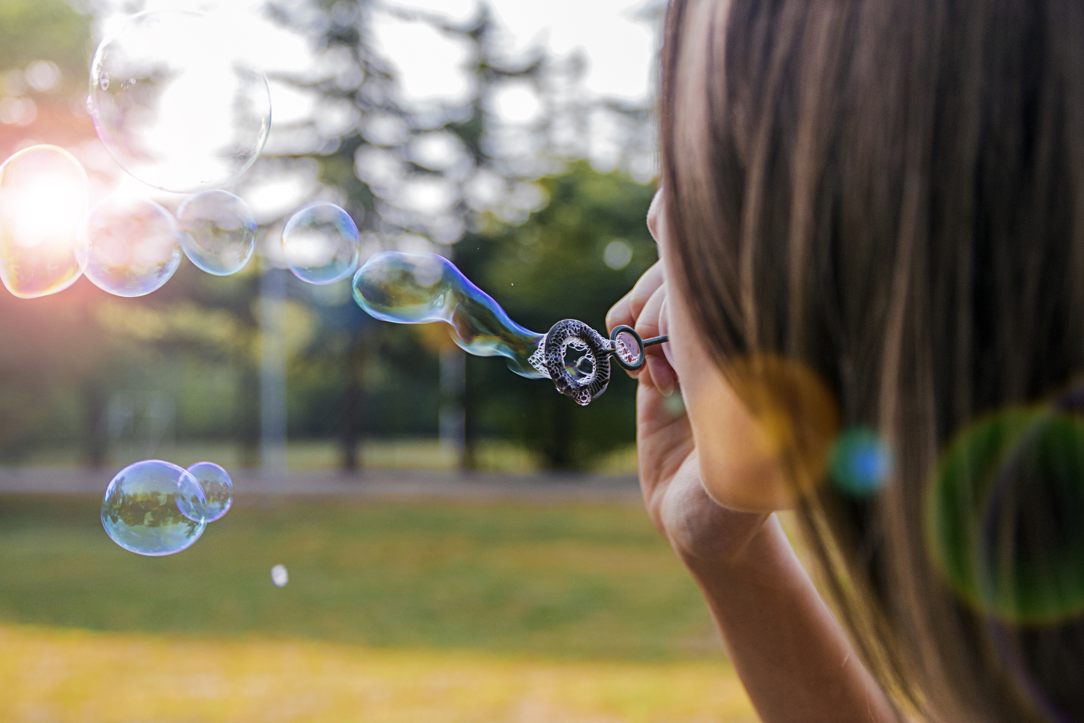 Photo of girl blowing bubble soap outdoor